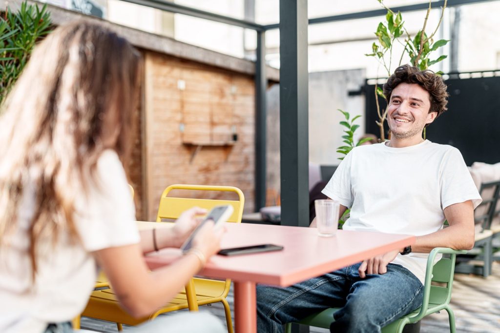2 personnes sur une terrasse discutant